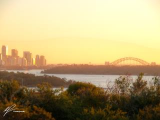 A view west from the Vaucluse headland towards the famous Sydney Harbour Bridge as the sun begins to set to the west.