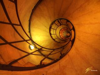 This is an artful shot looking up from inside a stairwell inside the legendary Arc de Triumph in Paris, France.